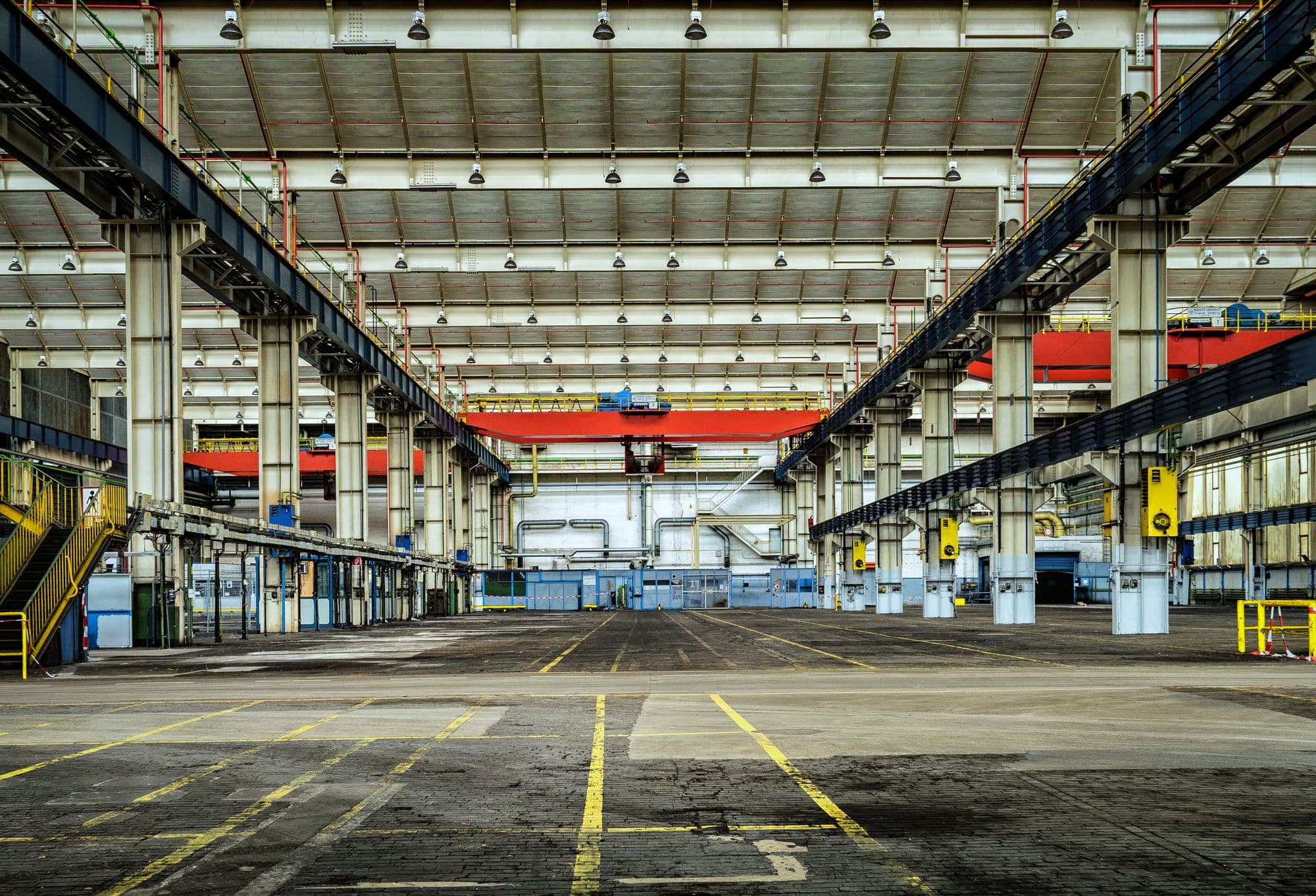 Industrial plant hall with overhead cranes and marked floor lanes