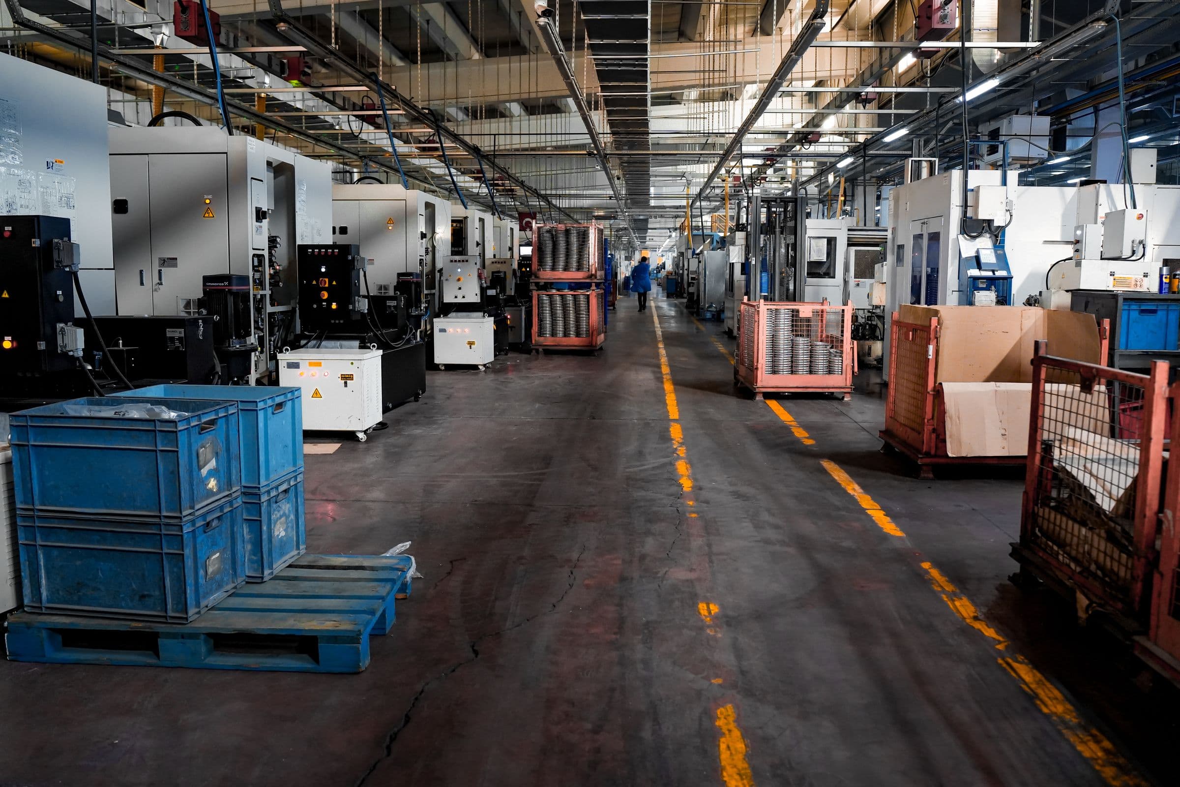 Manufacturing plant floor with production equipment along a marked aisle