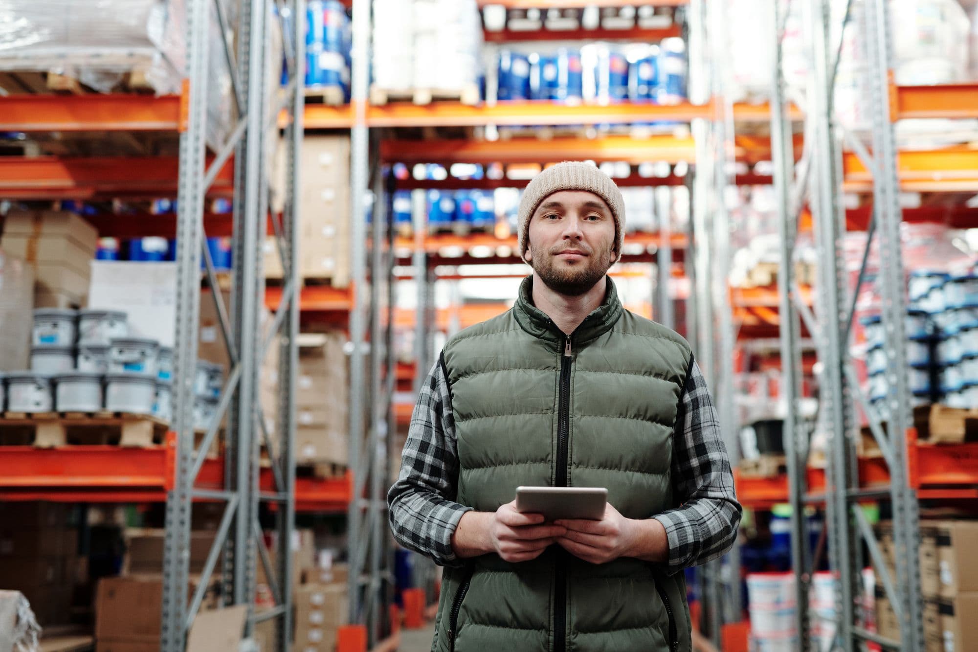 Operations professional reviewing work on a tablet in a warehouse